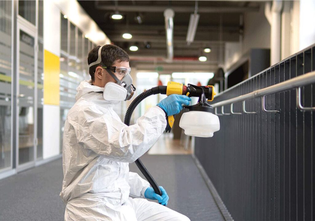 Homem aplicando pintura eletrostática em barra